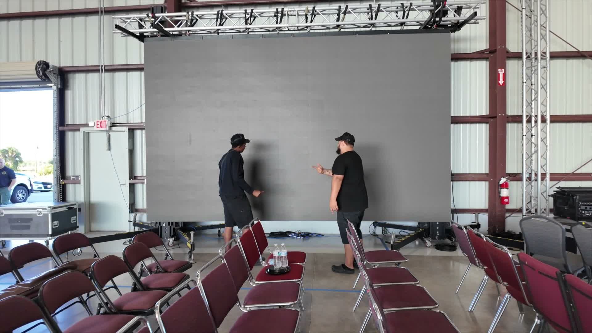 LCP crew installing a large LED video wall inside an aircraft hangar ahead of a law enforcement memorial service