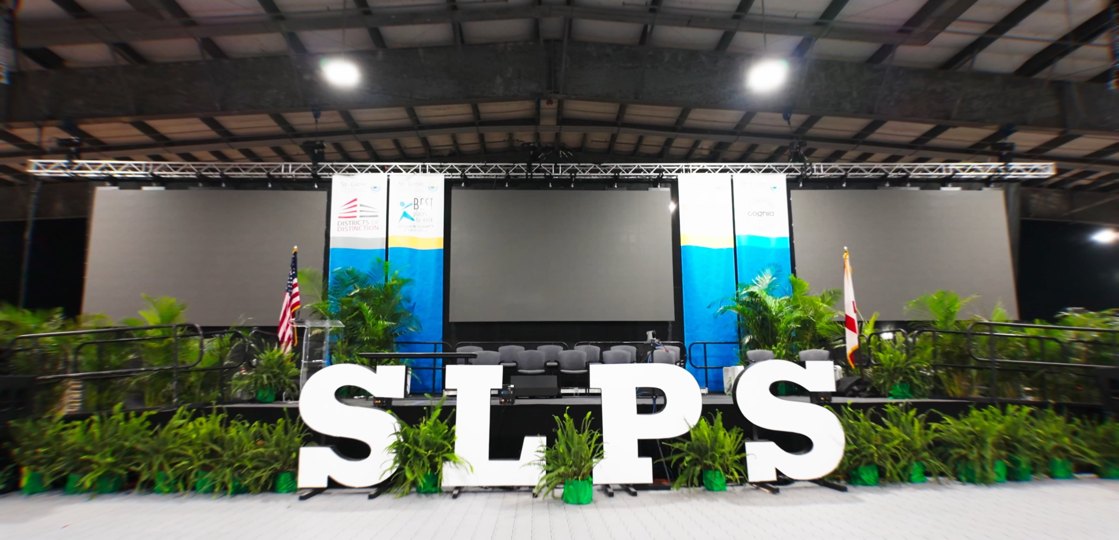 Three large truss-rigged IMAG LED walls flanking the stage at an SLPS high school graduation ceremony