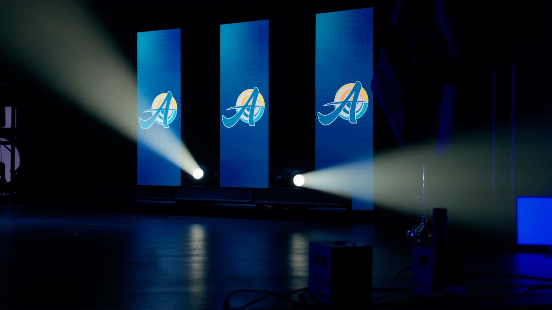 Three freestanding LED poster wall panels lit on stage at the SLPS kickoff event